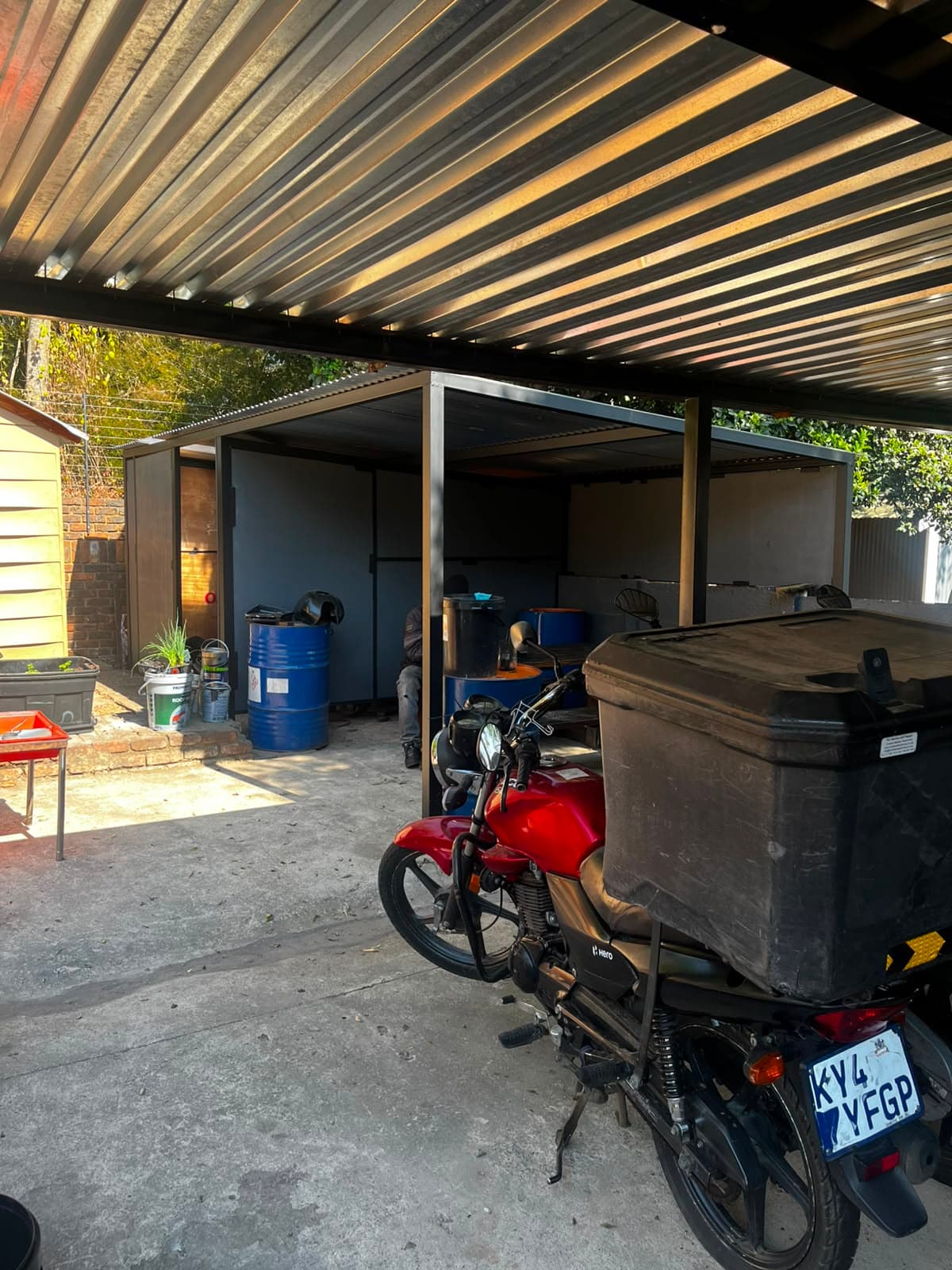 Delivery bike with top-box parked under the carport